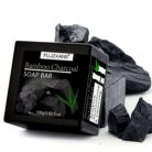 Bamboo charcoal soap bar box on a white background with pieces of charcoal