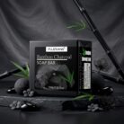 Bamboo charcoal soap bar on a dark stone display with bamboo leaves