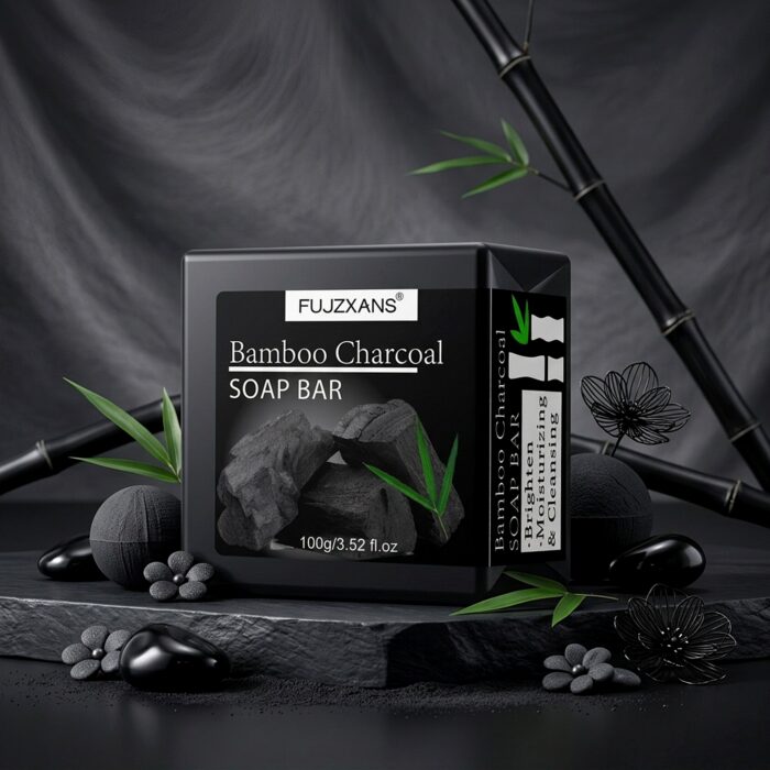 Bamboo Charcoal Cleansing Soap Bar, 100 g 3 Bamboo charcoal soap bar on a dark stone display with bamboo leaves