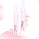 Two sakura serum ampoules on a soft pink background