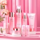 Hydrating face care set with toner, lotion, essence and cream on a pink background